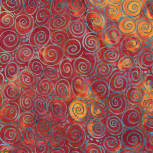 an image of red orange batik fabric with a pattern of scattered blue spirals