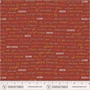 an image of rust-red fabric with a pattern of rows of apple-related words in yellow, orange, and white