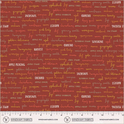 an image of rust-red fabric with a pattern of rows of apple-related words in yellow, orange, and white
