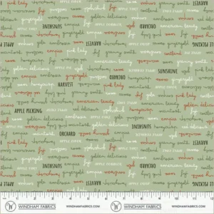an image of green fabric with a pattern of rows of apple-related words in black, green, orange, and white