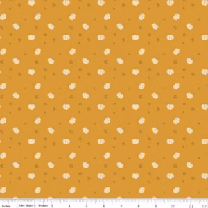 an image of golden yellow fabric with a pattern of tossed cream colored pumpkins
