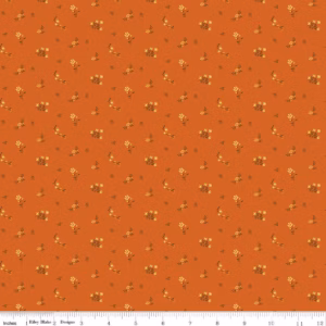 an image of orange fabric with a pattern of tossed floral sprigs