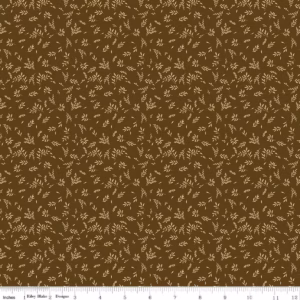an image of brown fabric with a pattern of tossed sprigs of leaves