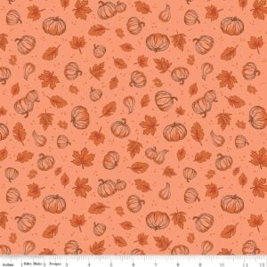 an image of light orange fabric with a pattern of tossed pumpkins and fall leaves