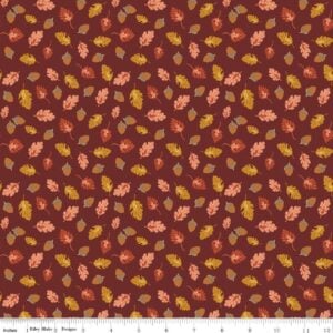 an image of rusty red fabric with a pattern of tossed acorns and fall leaves
