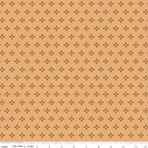 an image of golden brown fabric with a pattern of acorns arranged in clusters of 4 with their hats pointed outward