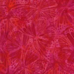 an image of orange pink batik fabric with an allover print of monarch butterfly wings
