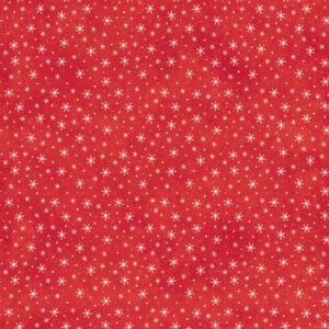 an image of red fabric with a pattern of tossed white snowflakes