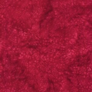 an image of red batik fabric with a pattern of small dots and squiggles