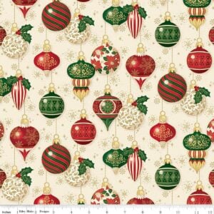 an image of cream colored fabric with a pattern of round and oblong old fashioned tree ornaments in red and green with gold foil accents